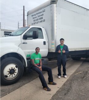 movers sitting against a truck posing for a picture
