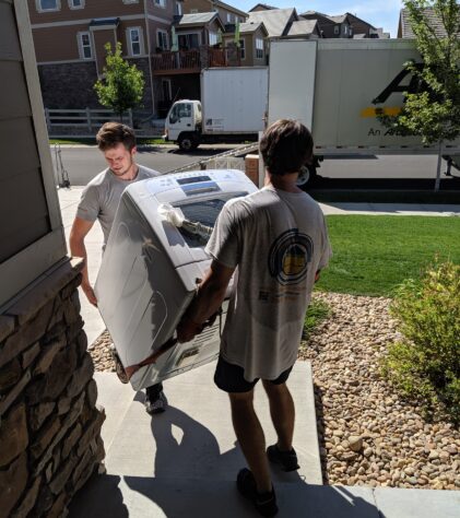 moving brothers moving an appliance inside a Denver home