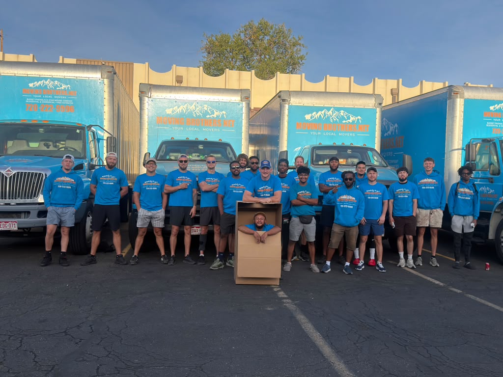 Moving Brothers team of Denver movers standing in front of four company moving trucks